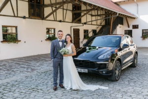 Brautpaar mit Hochzeitsauto auf dem Landgut Halsberg